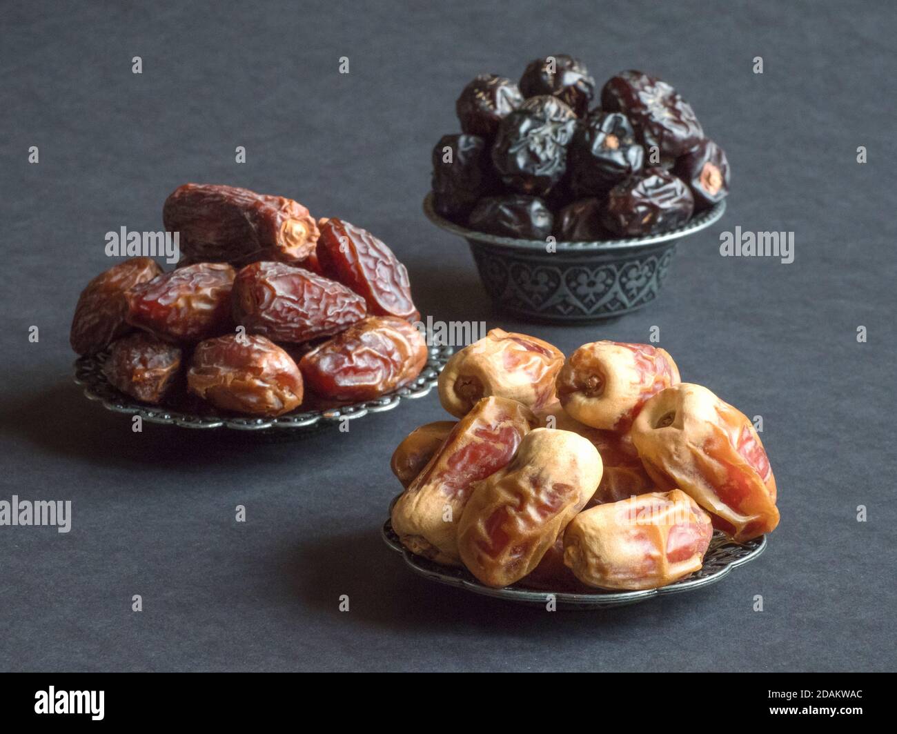 Arabic dates fruits are laid out on a dark table. Stock Photo