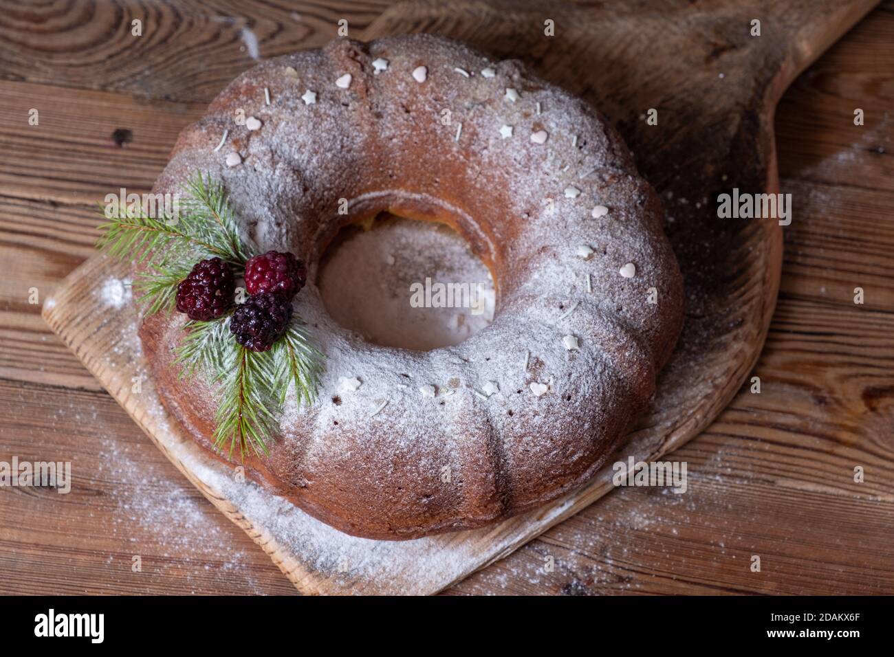 Christmas Round cake with icing sugar and decor on a wooden board ...