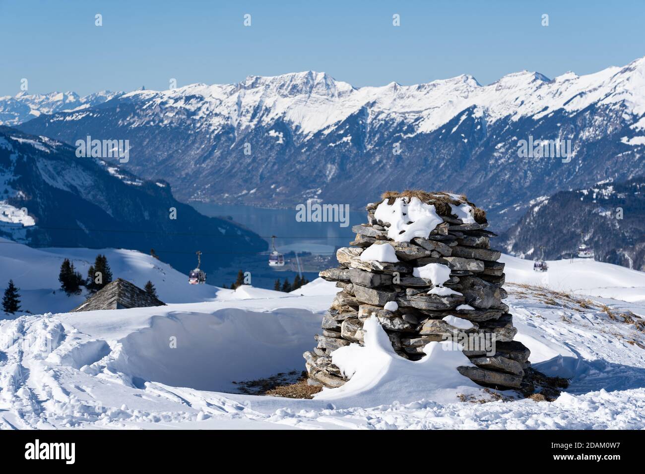 Stone stack in bernes alps with snow caped mountains and brienzersee in background. Focus on foreground Stock Photo