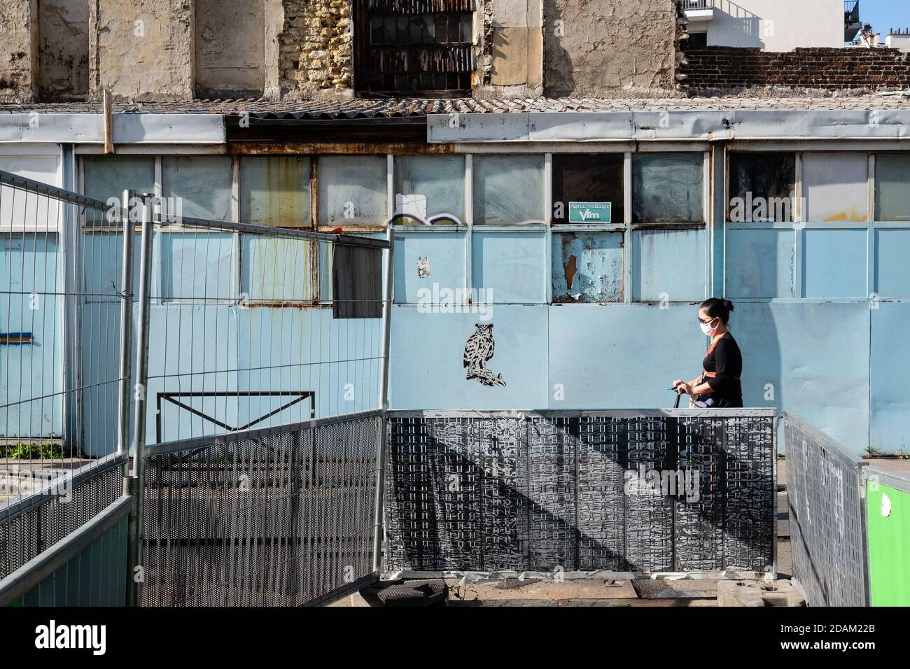 Woman with a mask and trottinette rue des Malmaisons Paris 13 Stock Photo