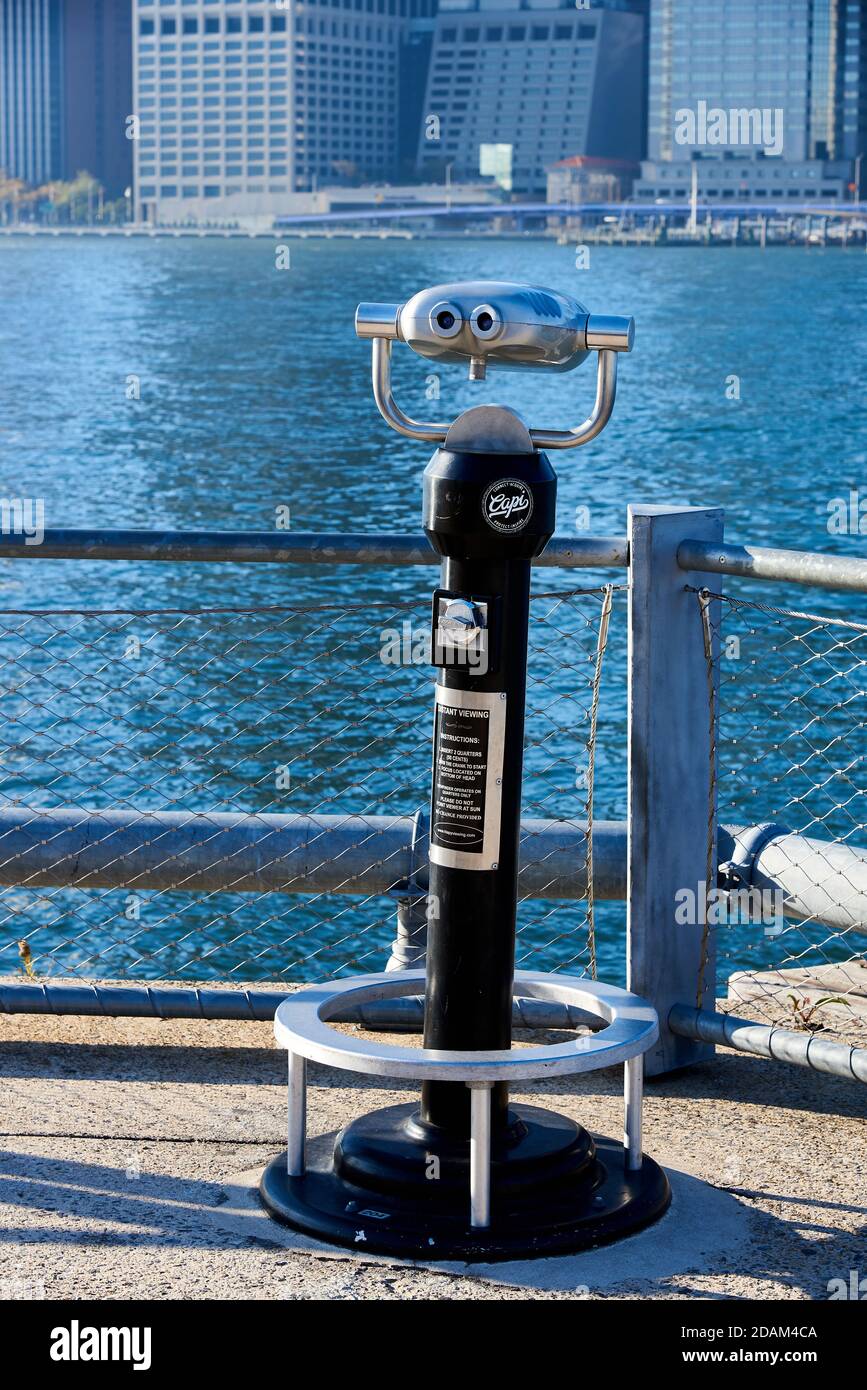 A coin-operated binocular scope is installed in Brooklyn Bridge Park on the East River. Stock Photo
