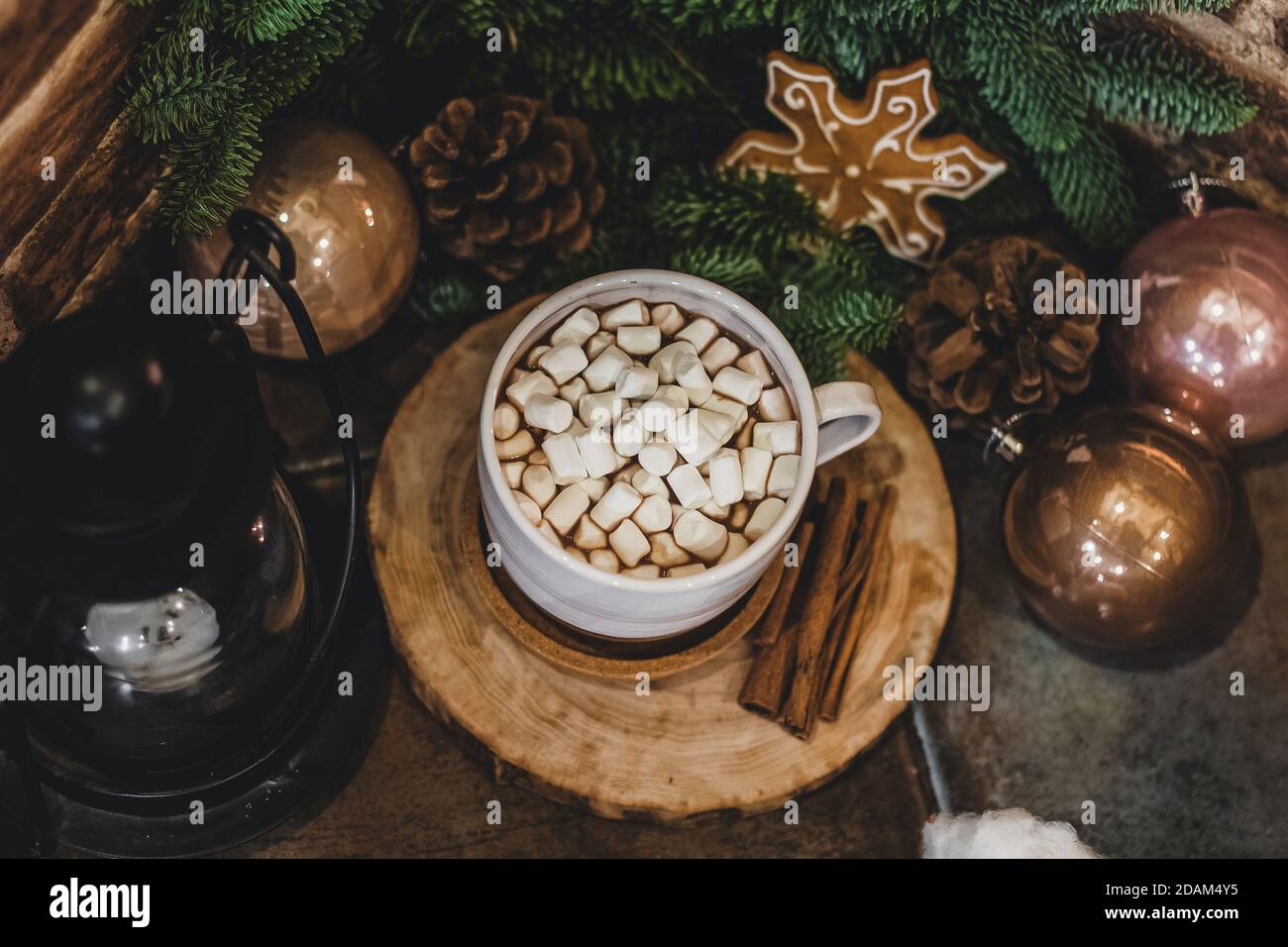 Christmas hot chocolate with mini marshmellows in an old ceramic mug with candles on a wooden background. Stock Photo