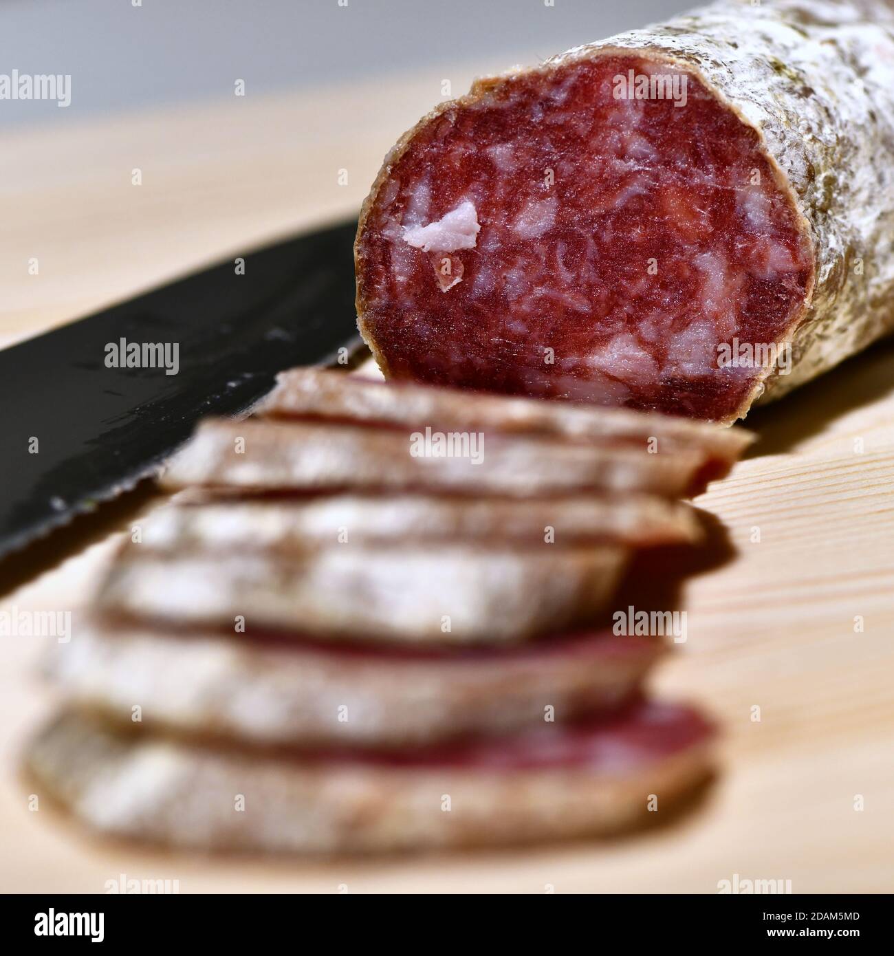 Slices of Italian artisanal Felino salami on a kitchen cutting board