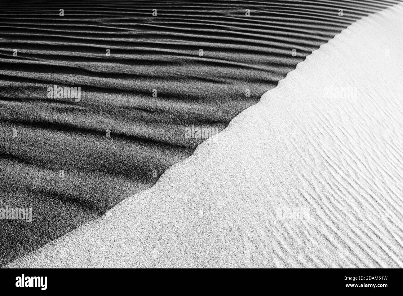 Black and White Sand beach macro photography. Texture of black and whote sand for background. Close-up macro view of volcanic sand surface black and w Stock Photo