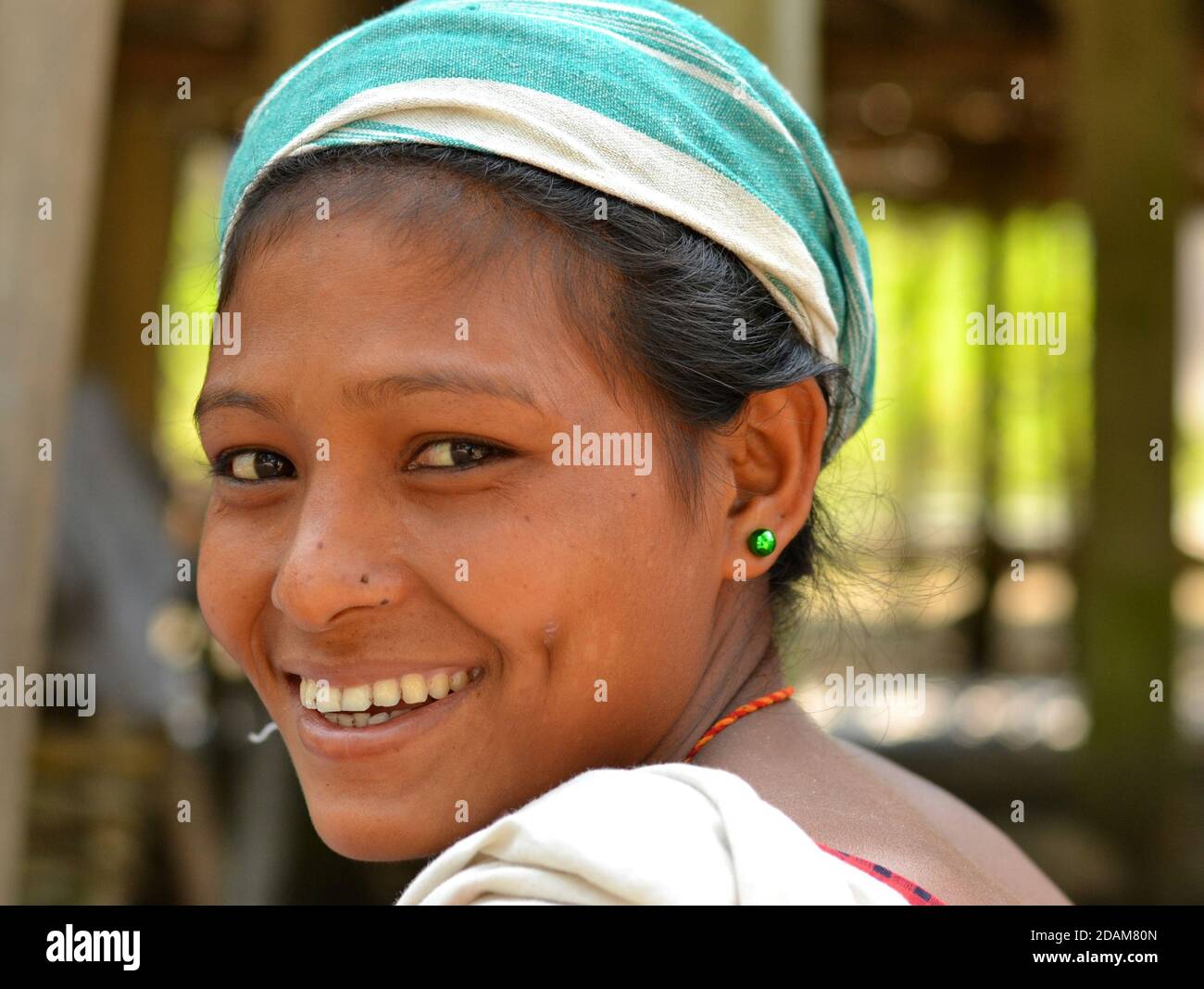 Young pretty Indian Mishing tribal woman from Majuli Island looks over her shoulder and smiles for the camera. Stock Photo