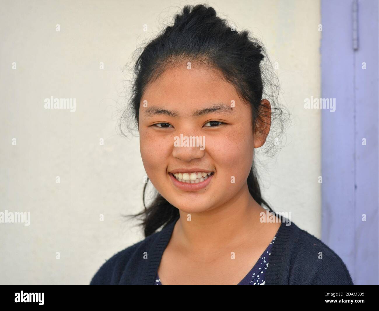 Modern young Northeast Indian Monpa woman smiles for the camera. Stock Photo