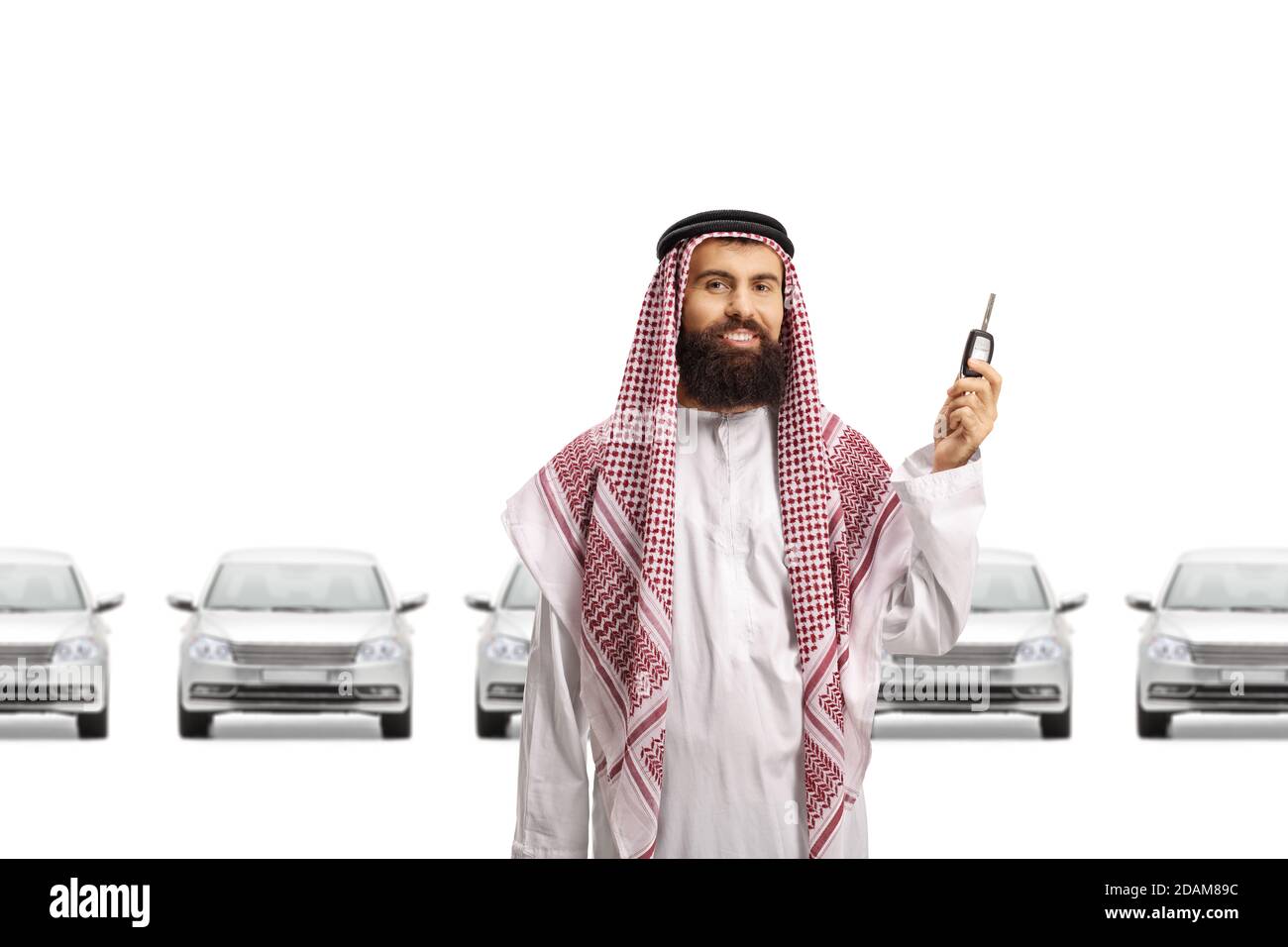 Saudi arab man smiling and showing keys and a row of silver cars behind him isolated on white background Stock Photo