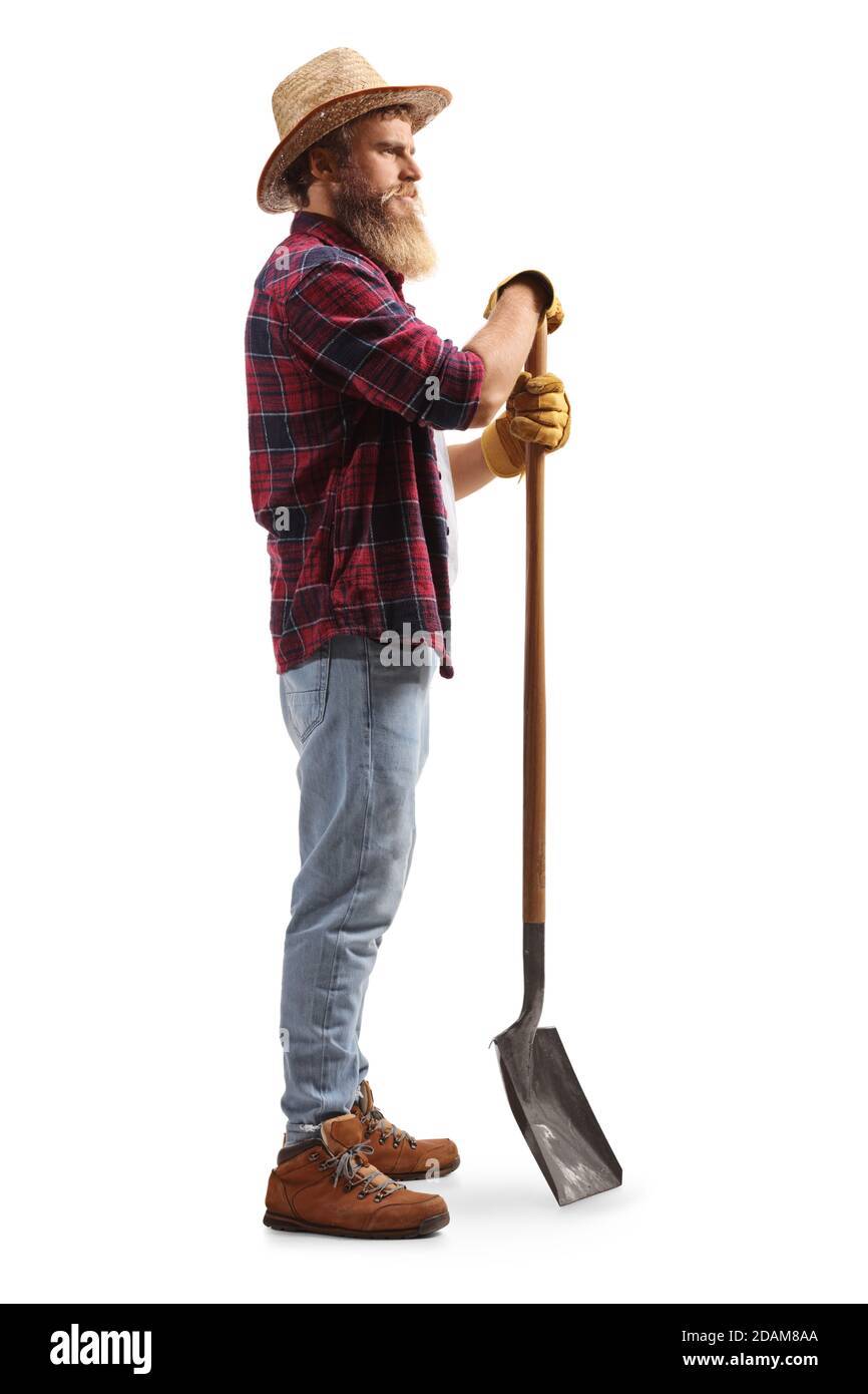 Full length profile shot of a bearded farmer leaning on a shovel isolated on white background Stock Photo