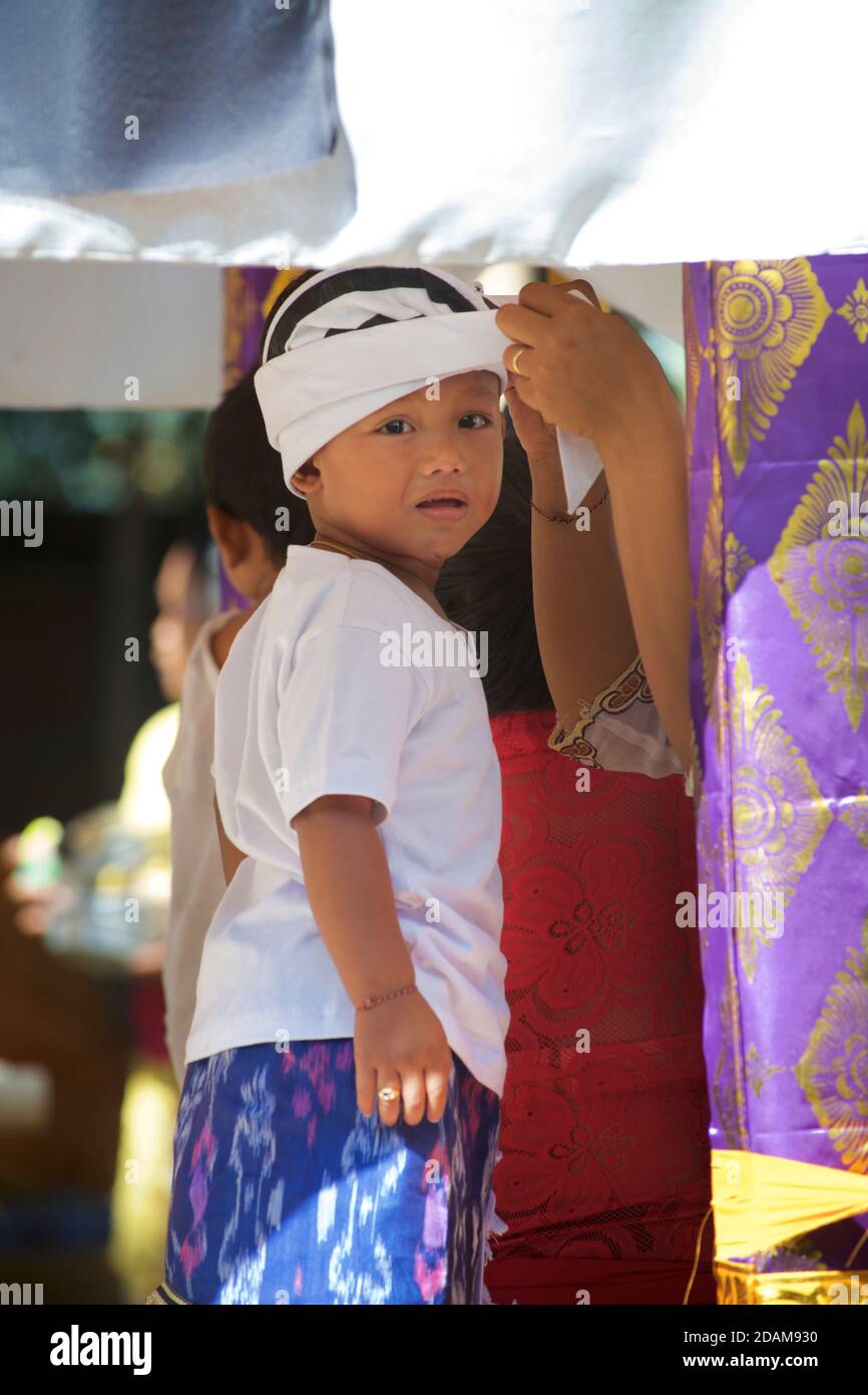Balinese boy in traditional attire attending a local temple for the start of the Galungan festival. Near Ubud, Bali, Indonesia Stock Photo
