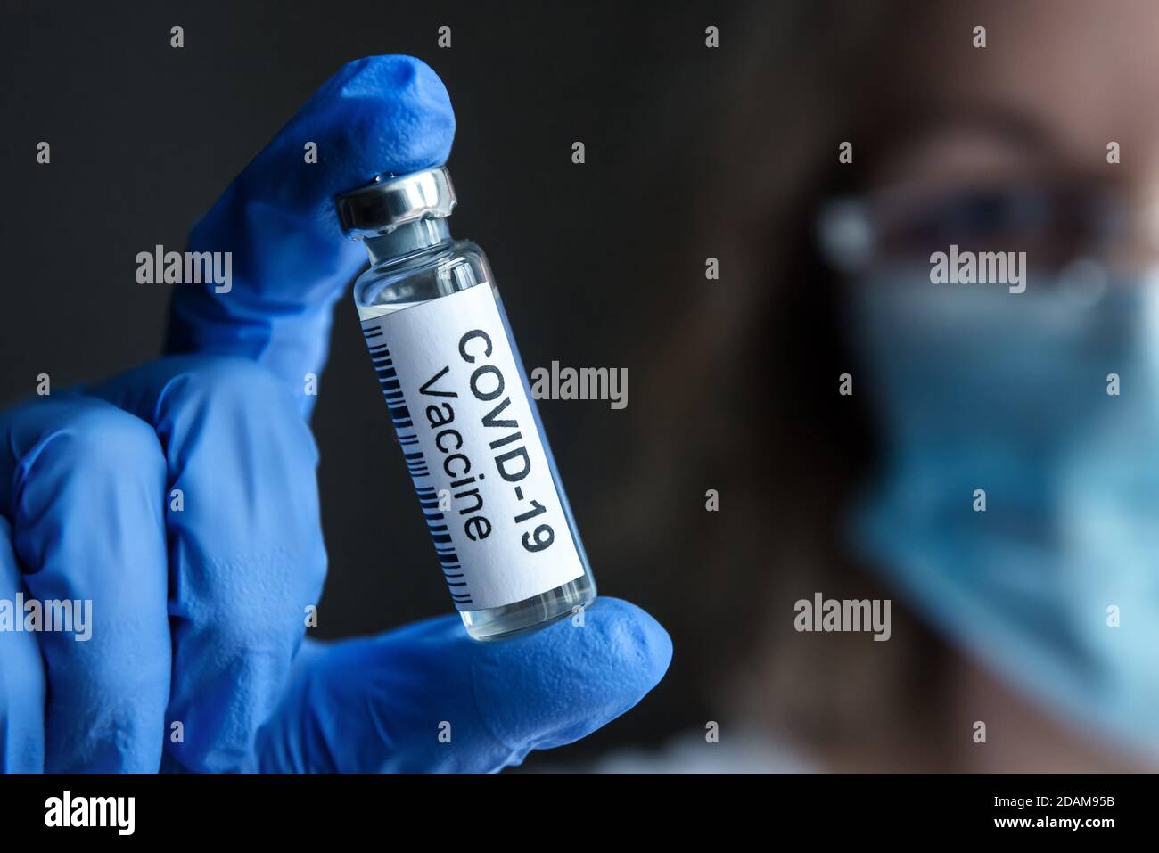 COVID-19 vaccine in researcher hand close-up, female doctor and bottle with medication for coronavirus cure in lab. Concept of corona virus treatment Stock Photo