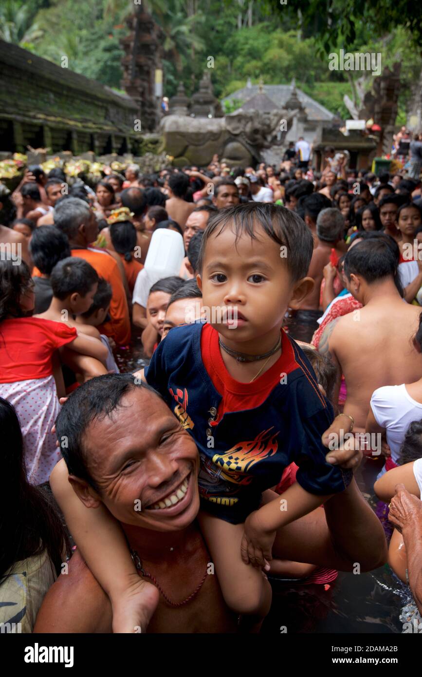 Balinese father and son in the ritual purifying bath at Tirta Empul ...
