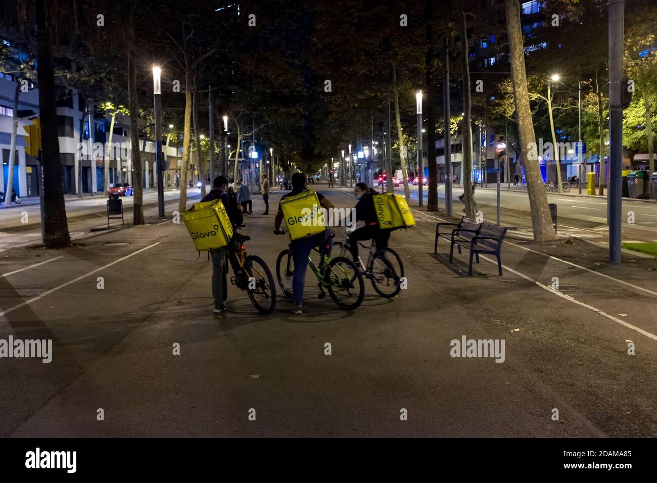 Barcelona, Catalonia, Spain. October 25th, 2020: Glovo deliverymen, on the Diagonal in its section that goes from the Plaza de las Glorias to the Forum moments before the first night of the curfew in Barcelona.              Much of the commercial fabric of Barcelona depends on tourism and is sized to serve these visitors, it is estimated that about 60% of its customers are non-residents. In the best of cases, it predicts that 30% of the shops in the center will disappear. On November 12, 2020, the Government of the Generalitat de Catalunya has decided to extend the closure of bars and restau Stock Photo