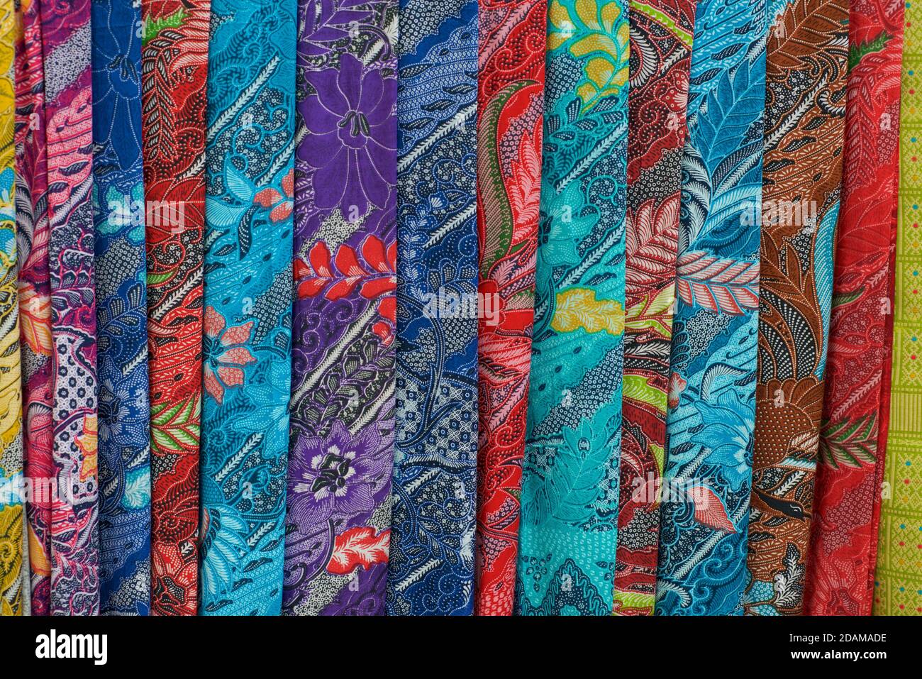 A selection of Balinese fabrics; brightly coloured sarongs for sale on a market stall. Bali. Indonesia Stock Photo