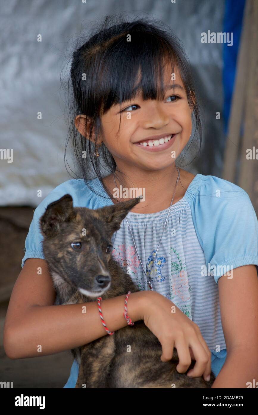 Portrait of an Indonesian girl with her pet puppy. Bali, Indonesia Stock Photo