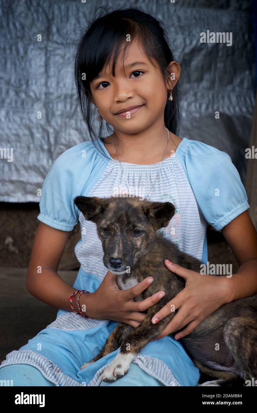 Portrait of an Indonesian girl with her pet puppy. Bali, Indonesia Stock Photo