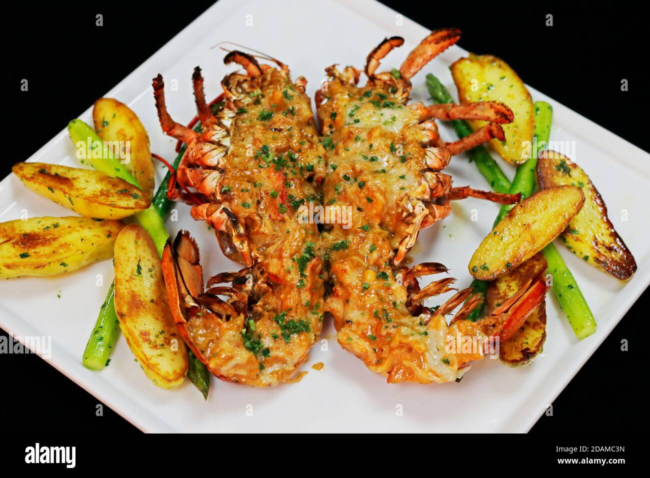 lobster thermidor served with glazed potato and asparagus in a platter