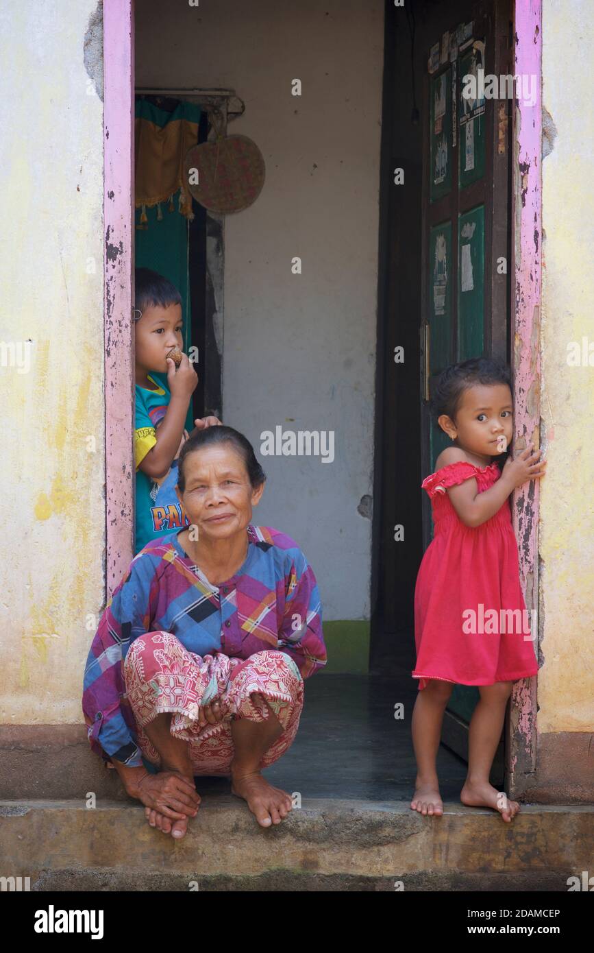 Indonesian woman and children at the door to their home, Lombok, Indonesia Stock Photo