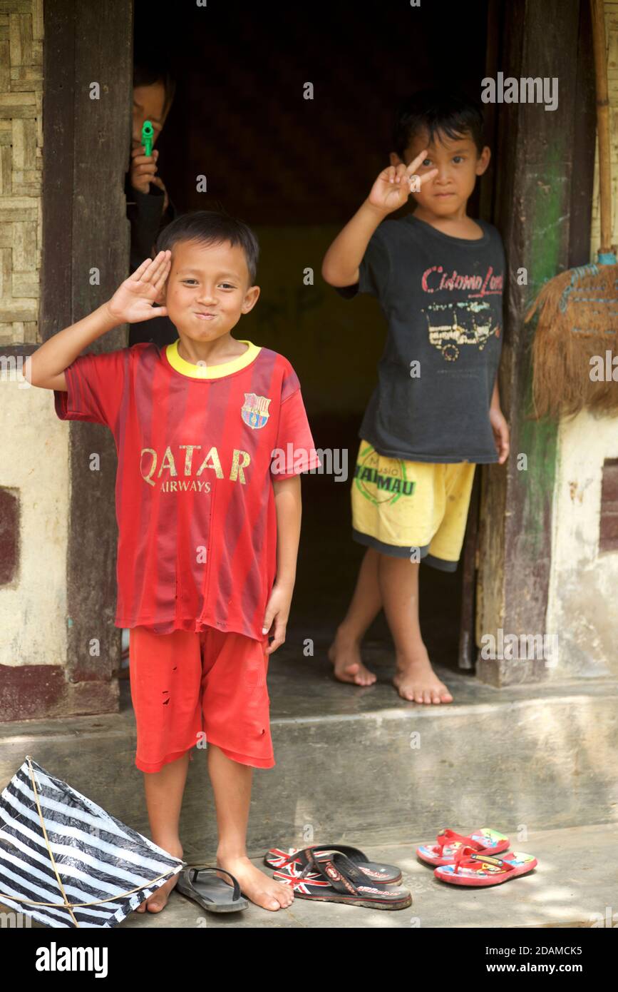 Local Indonesian boys from Tetebatu, Lombok in the doorway to their home. Lombok, Indonesia Stock Photo