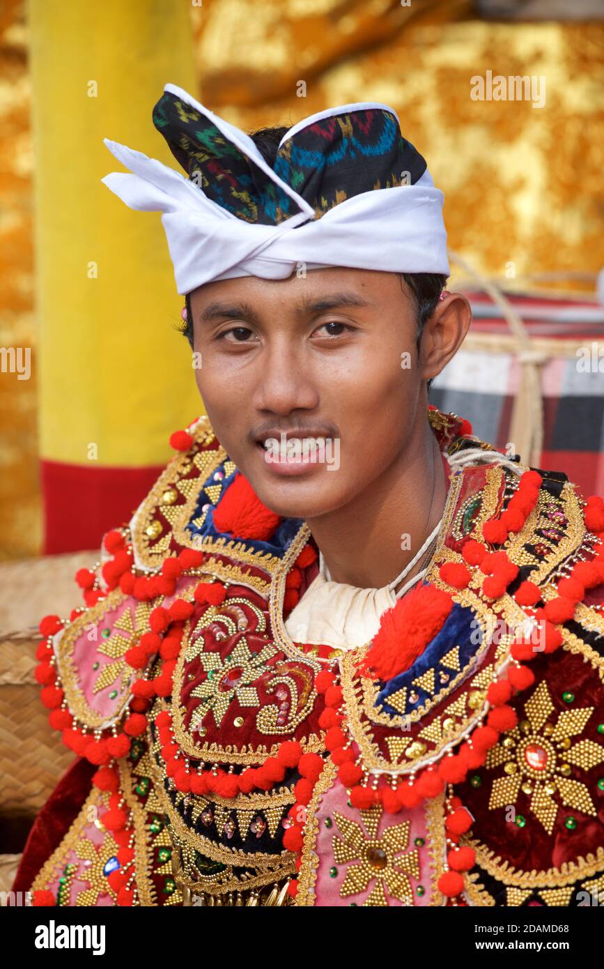 Young Balinese man in festive dance wear for temple ceremonial dance, Sakenan temple, Bali, Indonesia Stock Photo