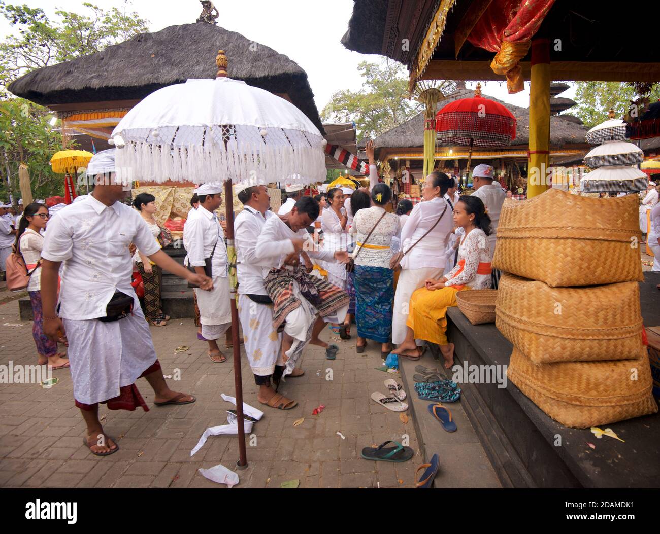 Balinese templegoers in festive attire at Sakenan temple, Bali, Indonesia..Some performers in the traditional dance events sucumb to a trance like state of possession after the dance performance and need exorcising. Stock Photo