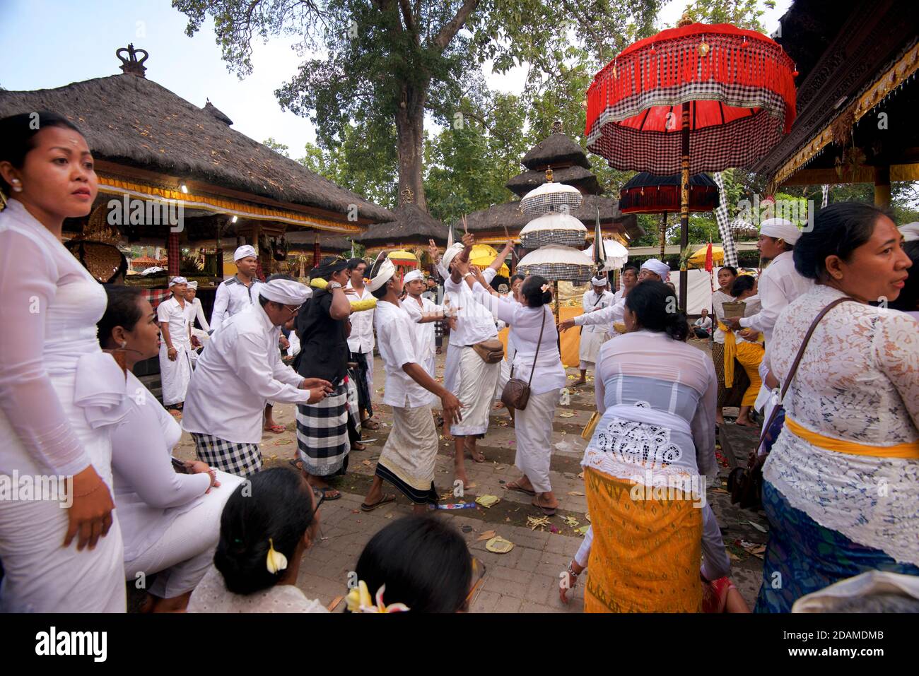 Balinese templegoers in festive attire at Sakenan temple, Bali, Indonesia. Some performers in the traditional dance events sucumb to a trance like state of possession after the dance performance and need exorcising. Stock Photo