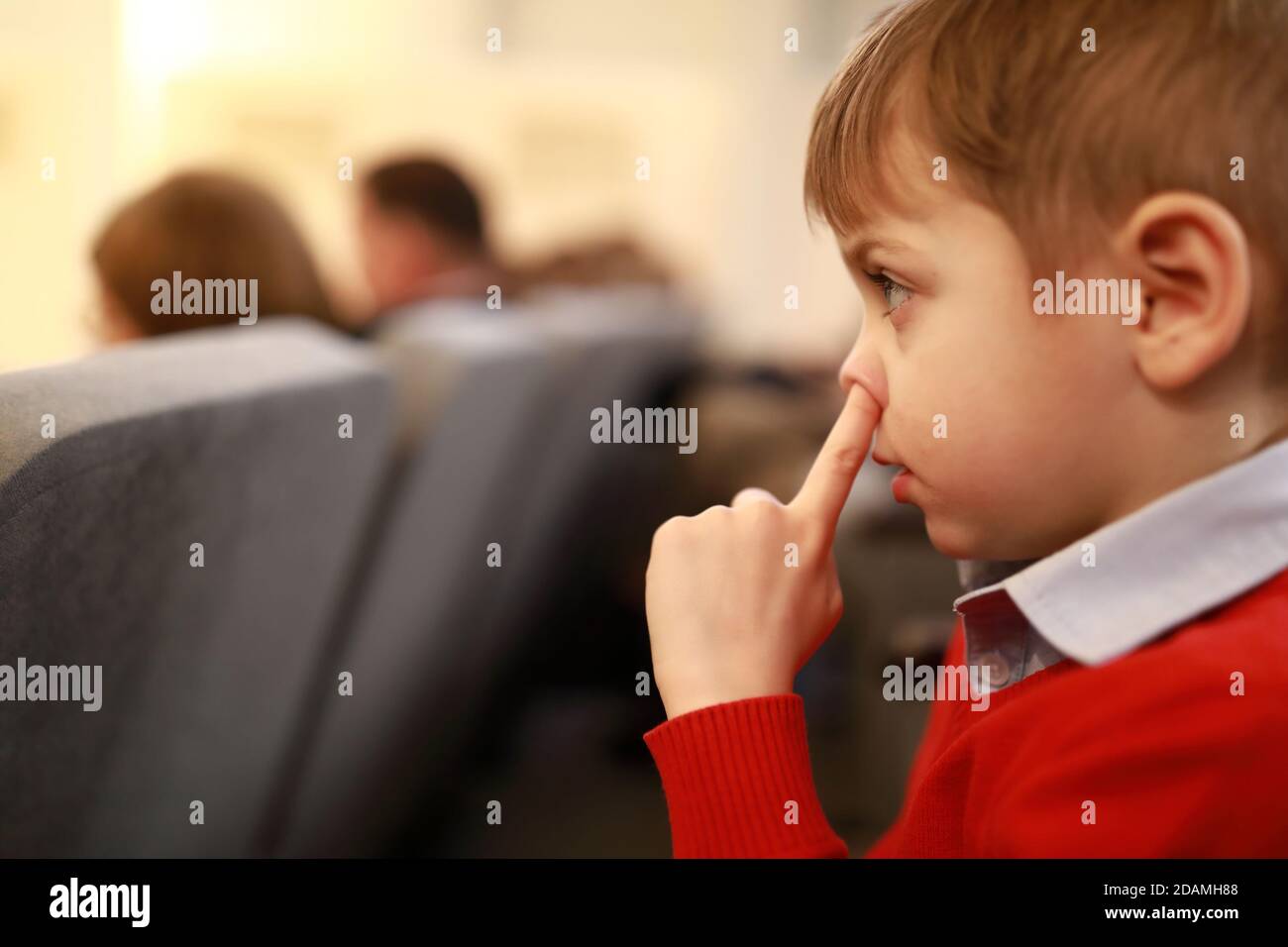 Child picks his nose in the theater Stock Photo