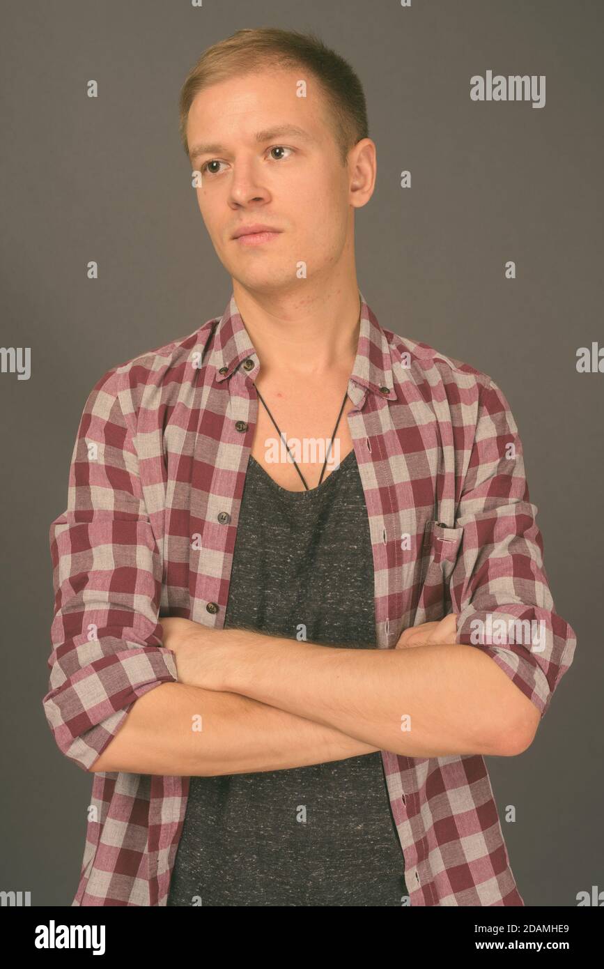 Portrait of young handsome man against gray background Stock Photo - Alamy