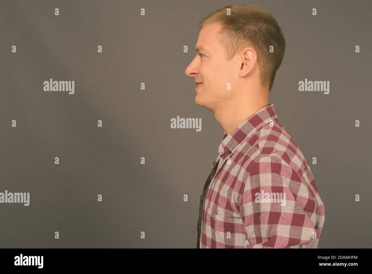 Portrait of young handsome man against gray background Stock Photo - Alamy