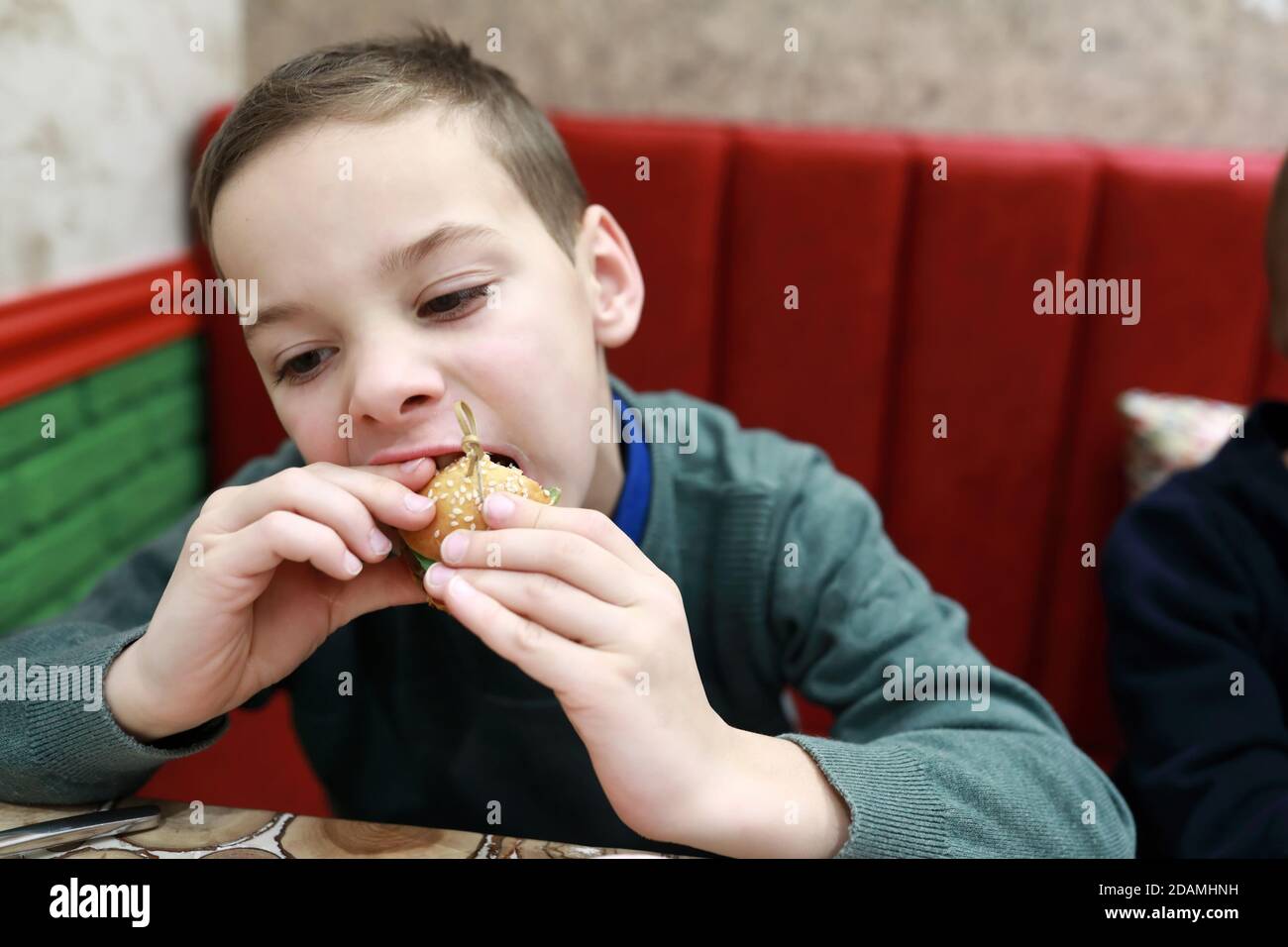 Child eating mini burger in a restaurant Stock Photo