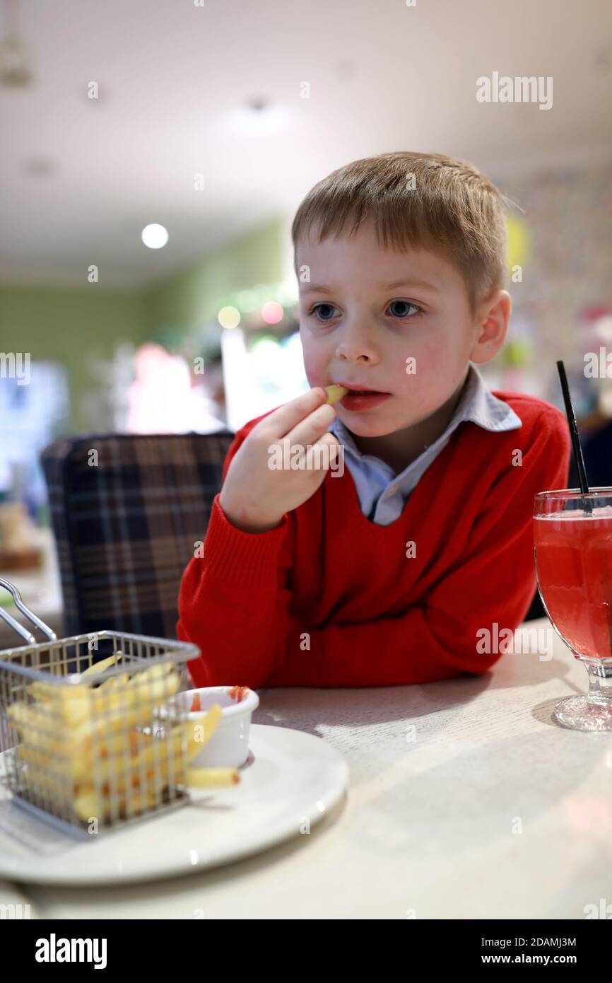 Kid eating french fries with ketchup in restaurant Stock Photo Alamy
