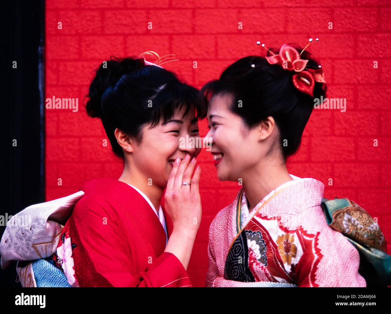 Two Japanese women in ceremonial dress kimonos, meet on a Tokyo, Japan street. Stock Photo