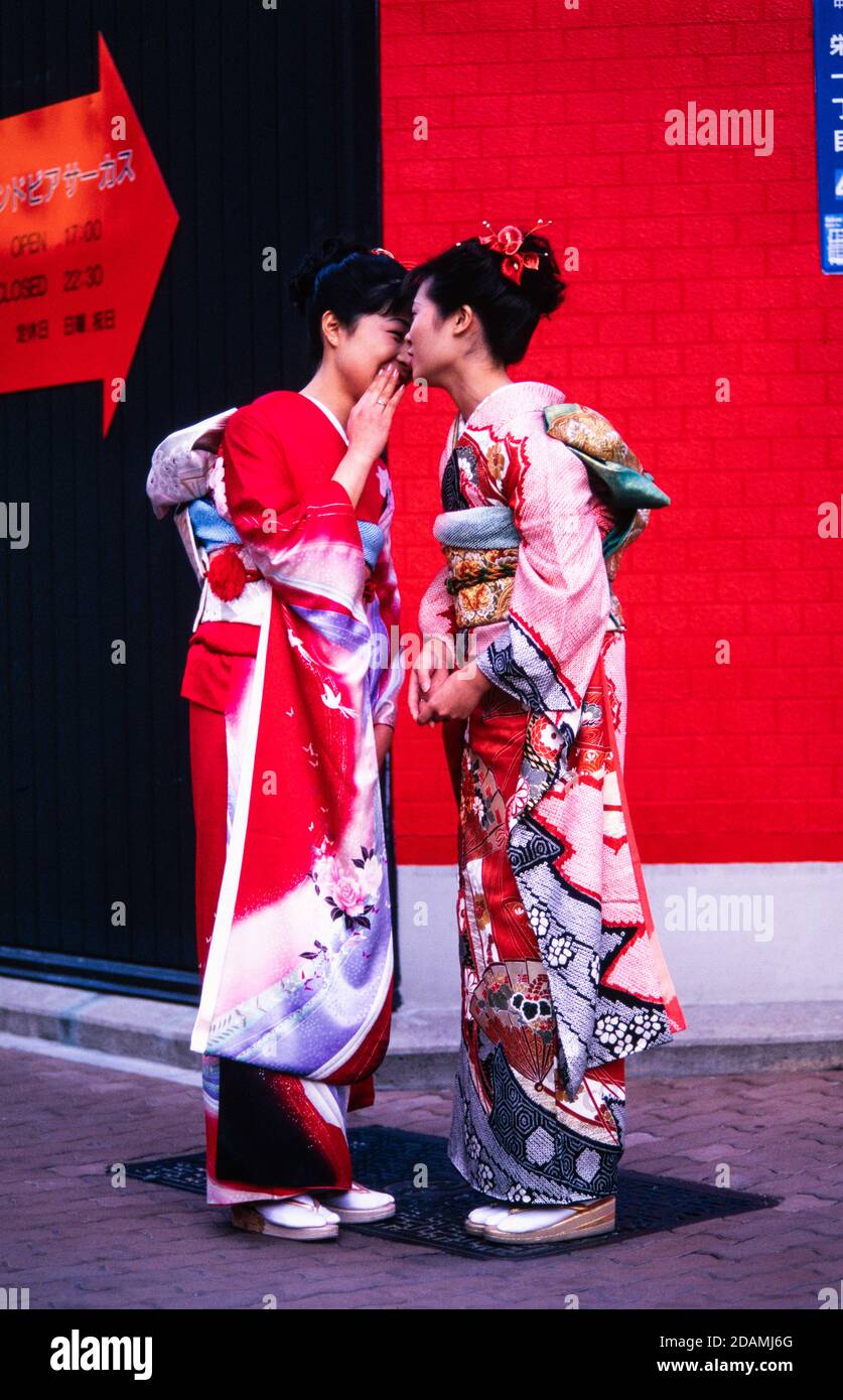 Two Japanese women in ceremonial dress kimonos, meet on a Tokyo, Japan street. Stock Photo