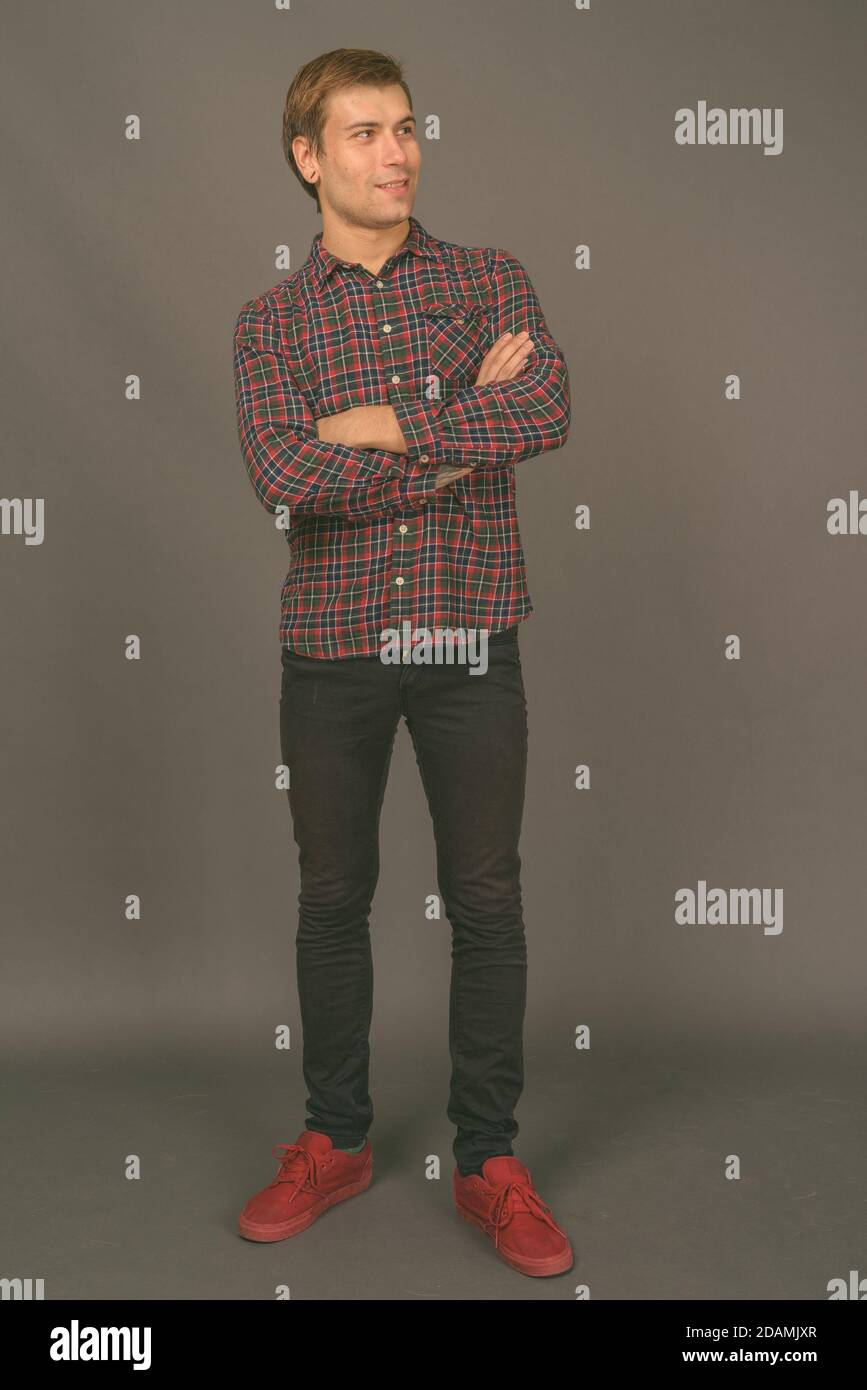 Portrait of young handsome man against gray background Stock Photo - Alamy