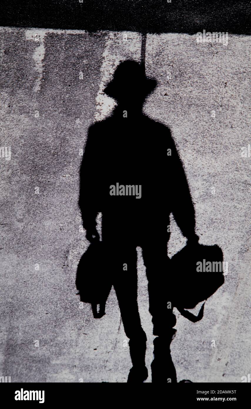 Pedestrian shadows on a blacktop road. A shadow is a dark (real image ...