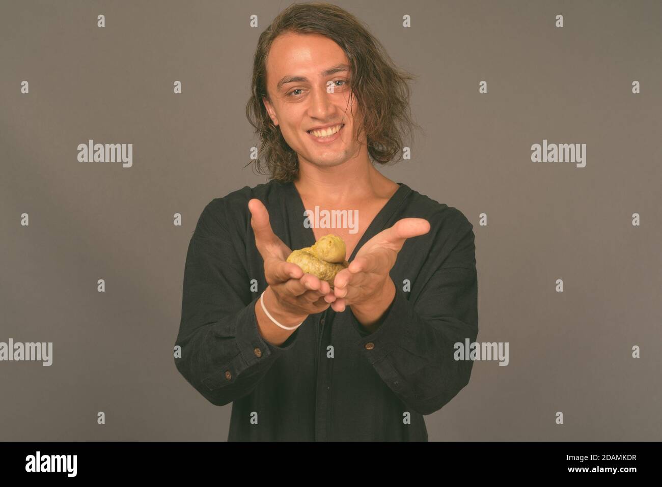 Portrait of young handsome man against gray background Stock Photo - Alamy