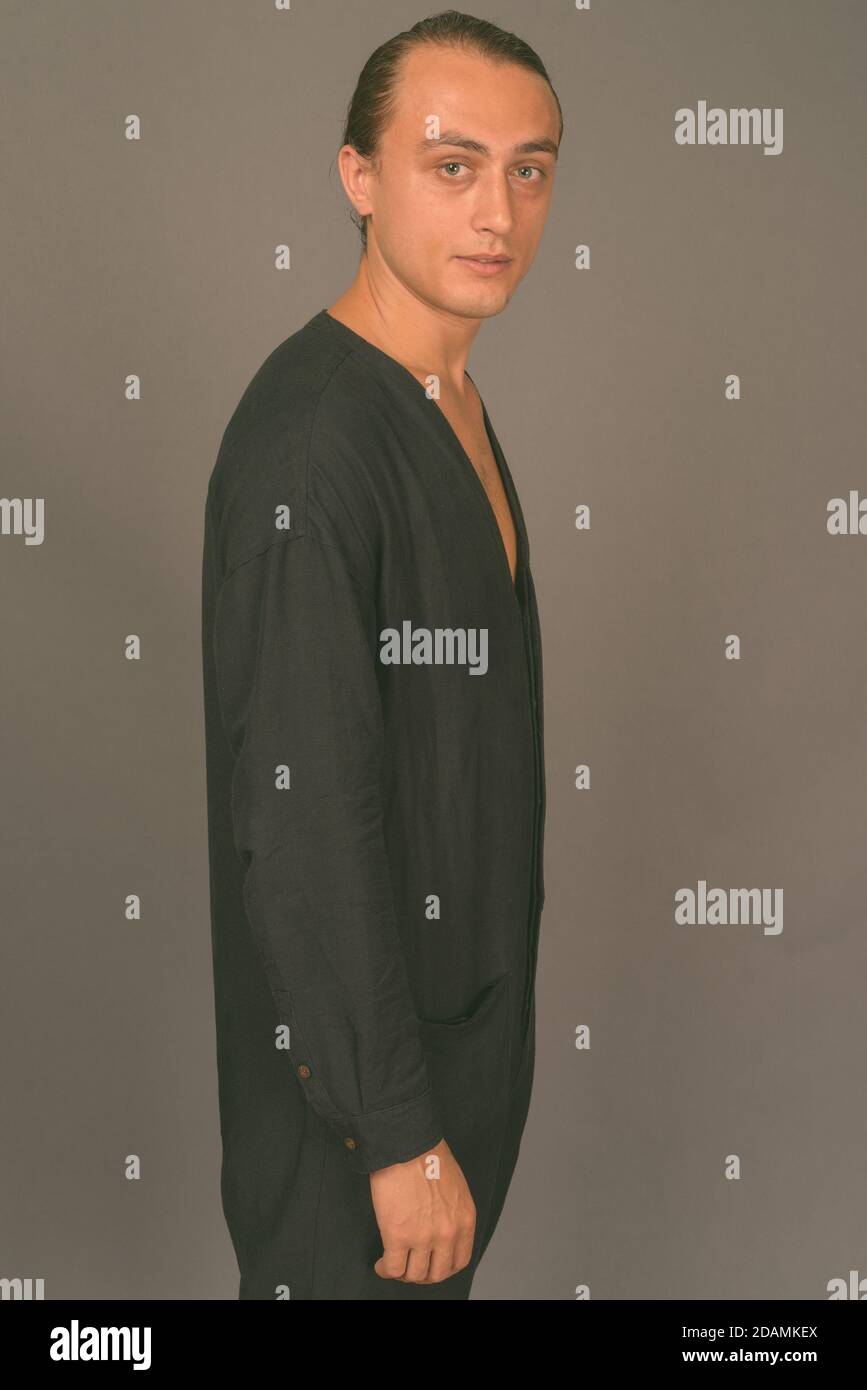 Portrait of young handsome man against gray background Stock Photo - Alamy