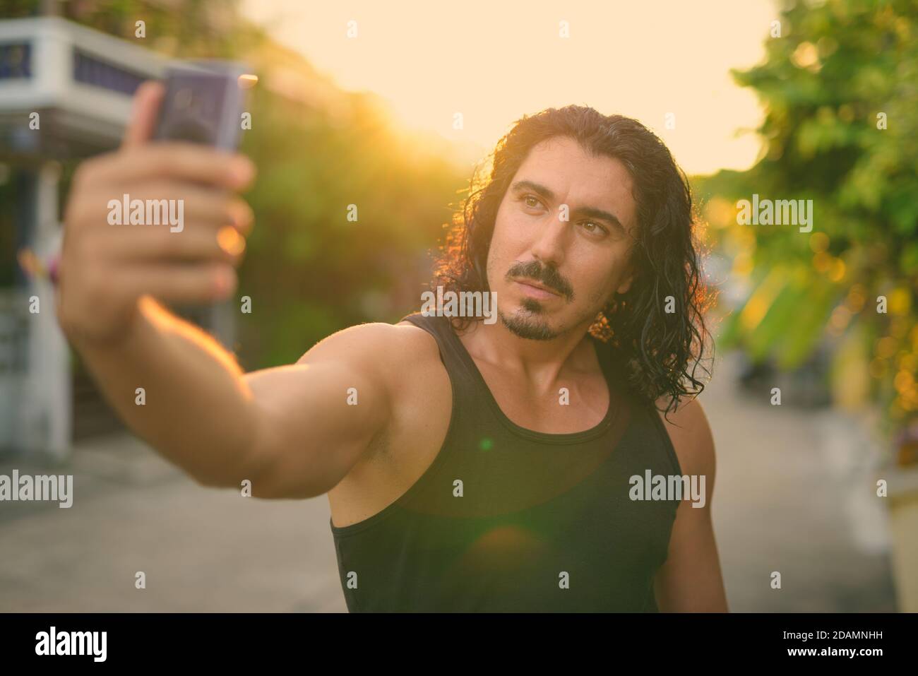 Handsome man with curly hair and mustache in the streets outdoors Stock Photo