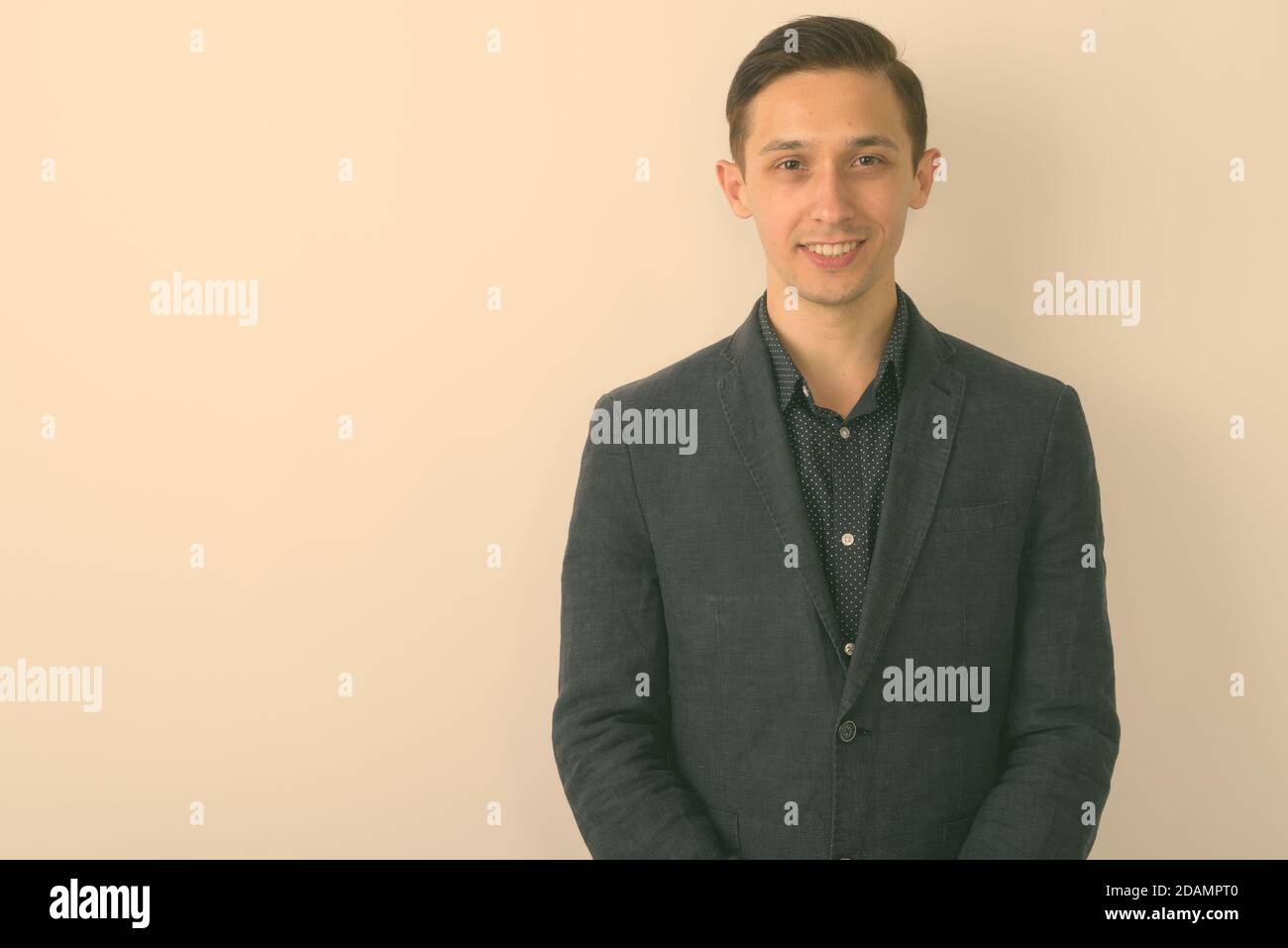 Studio shot of young happy businessman smiling against white background ...