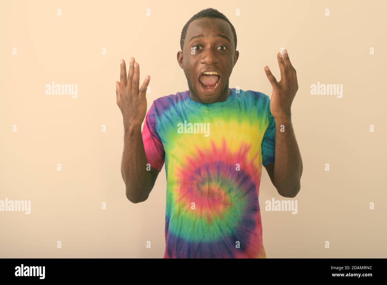 Studio shot of young surprised black African man looking shocked against white background Stock Photo