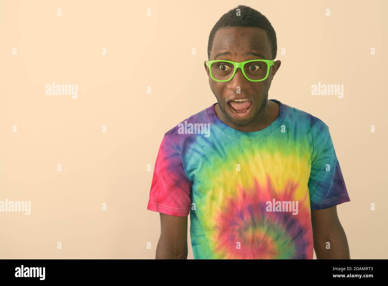 Studio shot of young suprised black African man looking shocked against white background Stock Photo