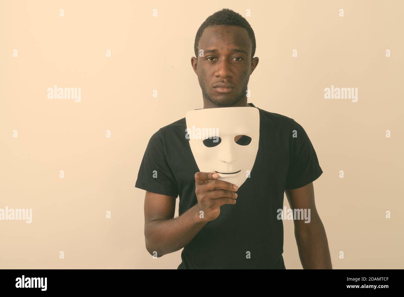 Masked man, double exposure with mask in hand and facial features partly  appearing through mask on face Stock Photo - Alamy