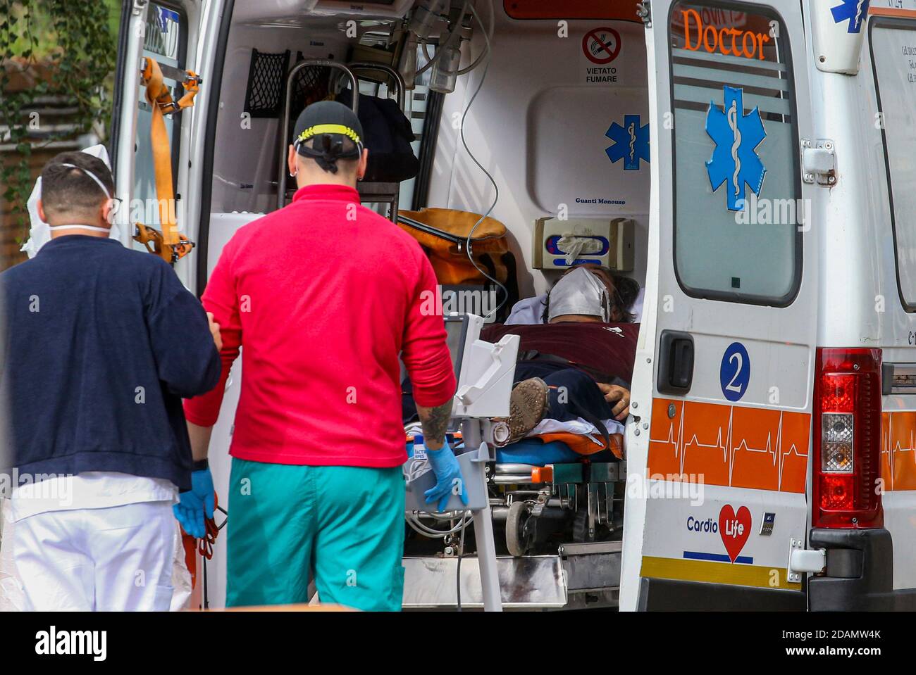 Doctors outside the facility carry out assessments of the condition of patients inside the ambulance. Hospitals in Italy are said to be facing a break Stock Photo