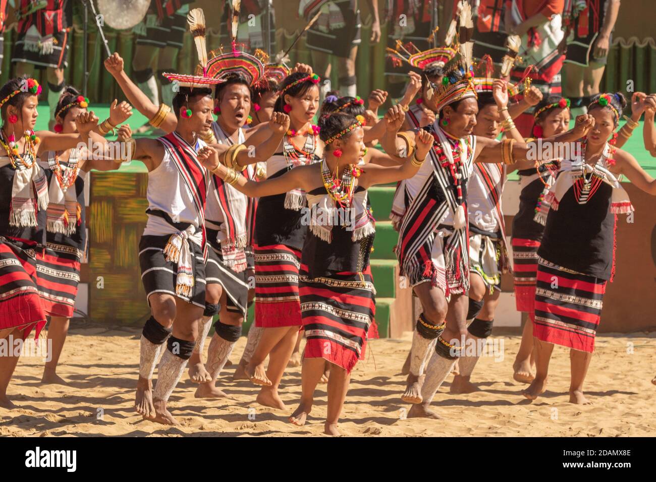 Group of naga tribesmen and women  dressed in their traditional attire dancing during Hornbill festival in Nagaland India on 4 December 2016 Stock Photo