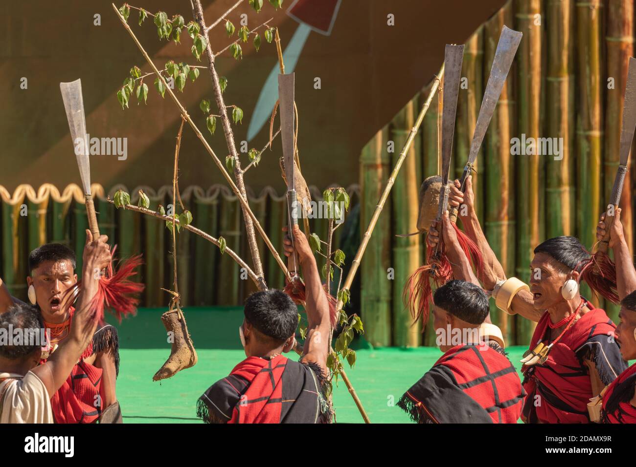 Naga tribesmen dressed in their traditional attire celebrating a victory by lifting their weapons in Kisama village Nagaland on 4 December 2016 Stock Photo