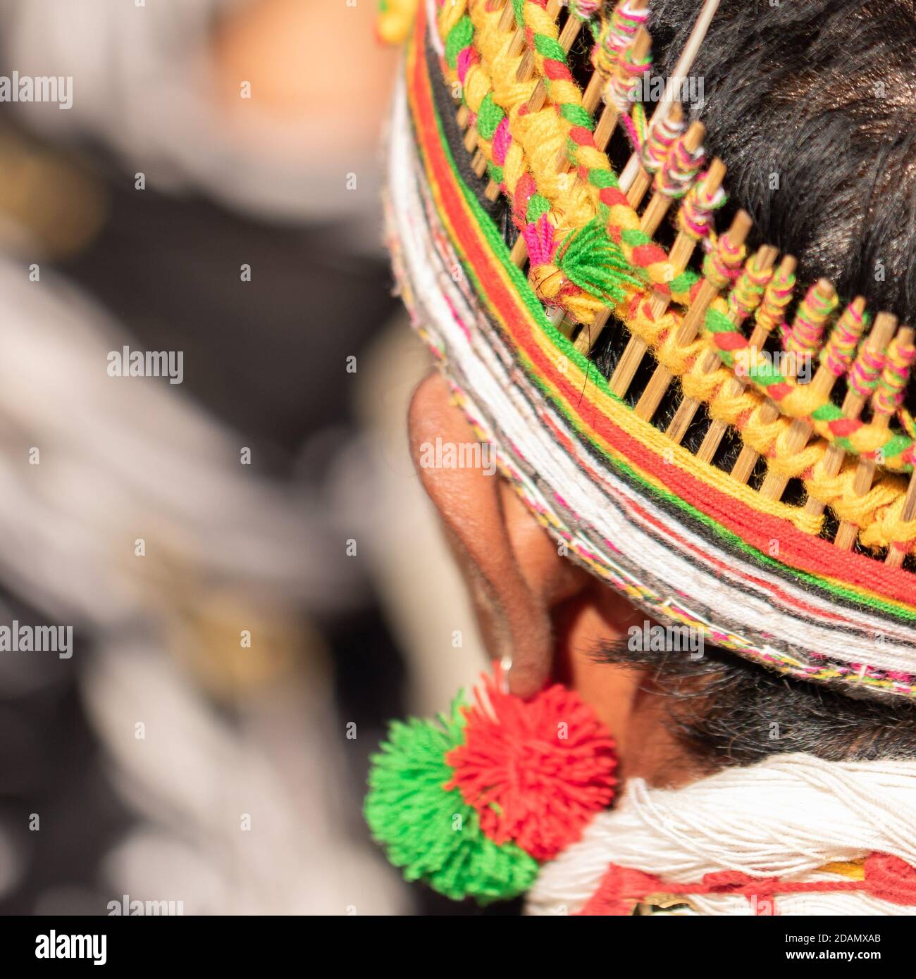 Abstract Portrait of a Naga tribesman dressed in his tribal attire wearing a colorful traditional headgear at Kisama Nagaland India on 4 December 2016 Stock Photo