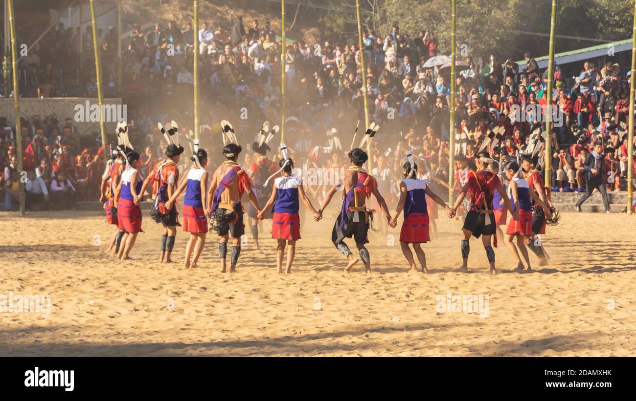 Group of naga tribesmen and women  dressed in their traditional attire dancing during Hornbill festival in Nagaland India on 4 December 2016 Stock Photo