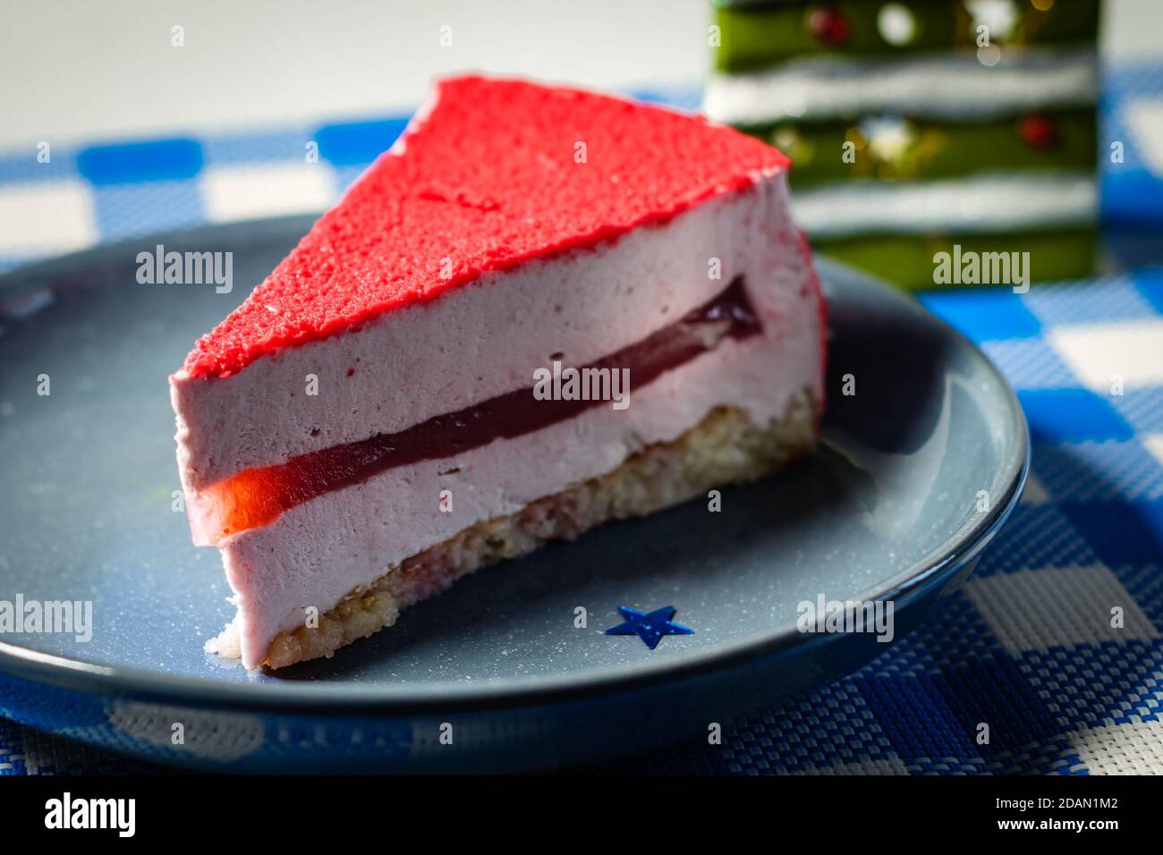 Raspberry holiday cheesecake Servings on a table with white blue  checkered tablecloth Stock Photo