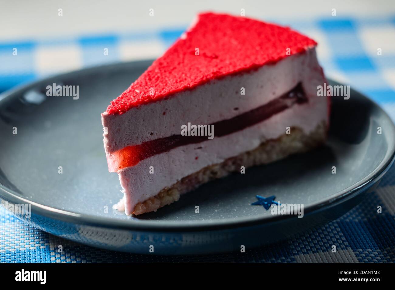 Raspberry holiday cheesecake Servings on a table with white blue  checkered tablecloth Stock Photo