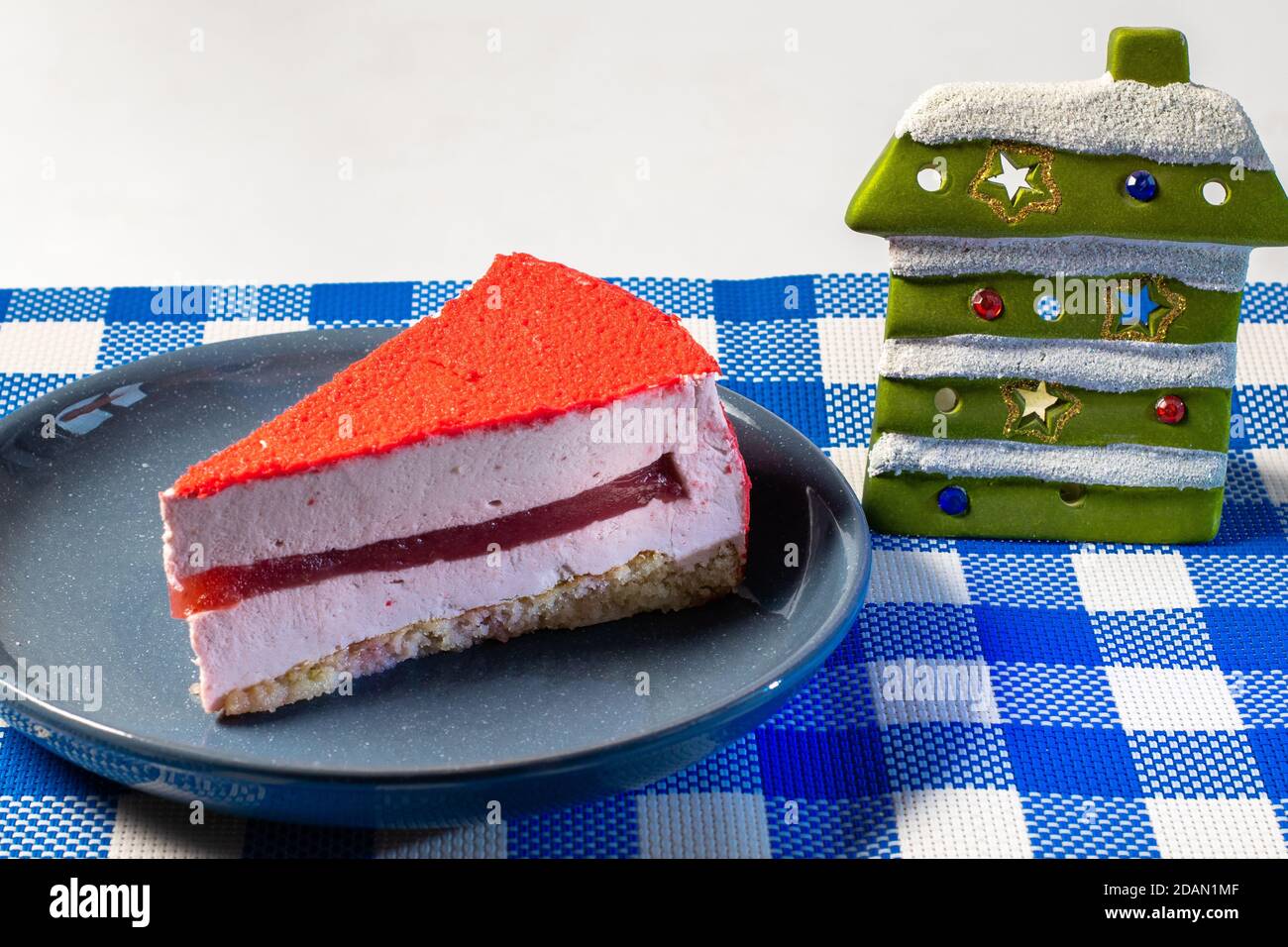 Raspberry holiday cheesecake Servings on a table with white blue checkered tablecloth Stock Photo