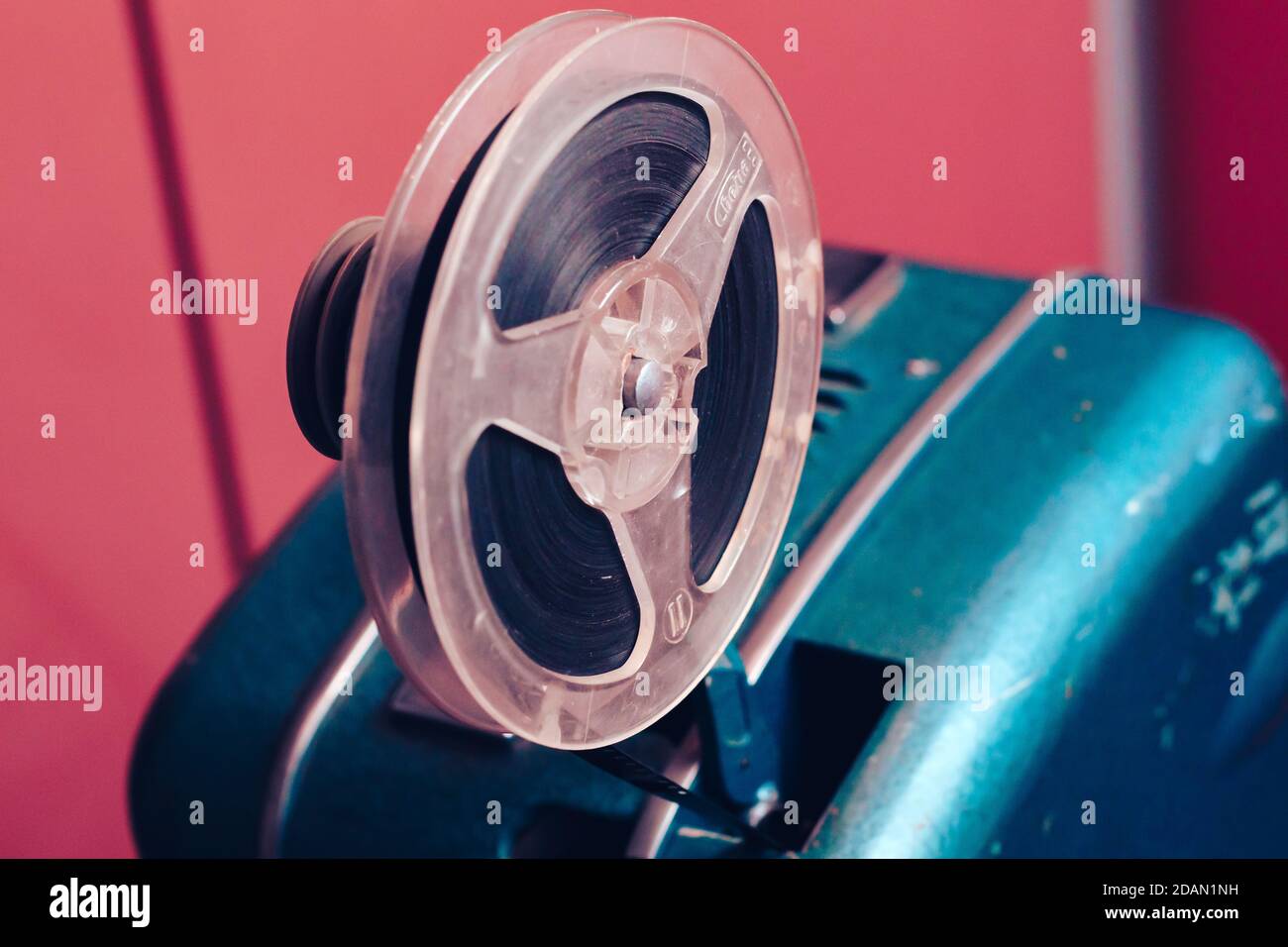 Old 8mm Film Projector over pink textured background. Retro style 60's banner concept Stock Photo